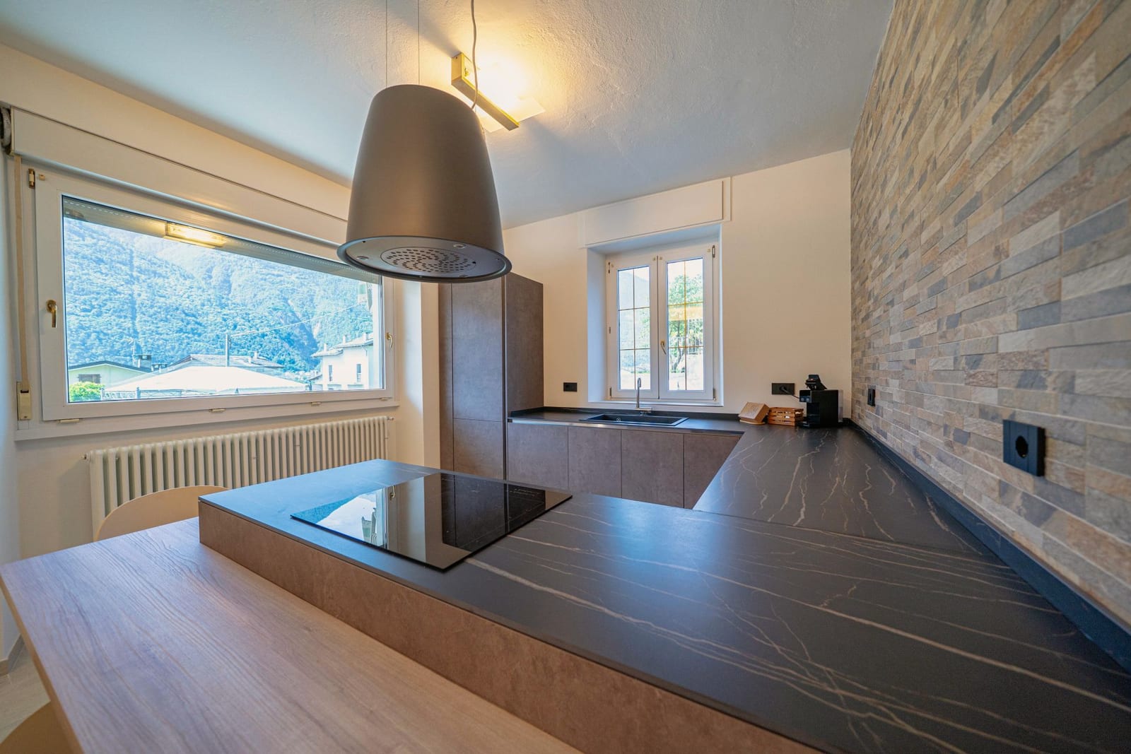 Suite Ambra — cucina con piano induzione e vista sulle Alpi